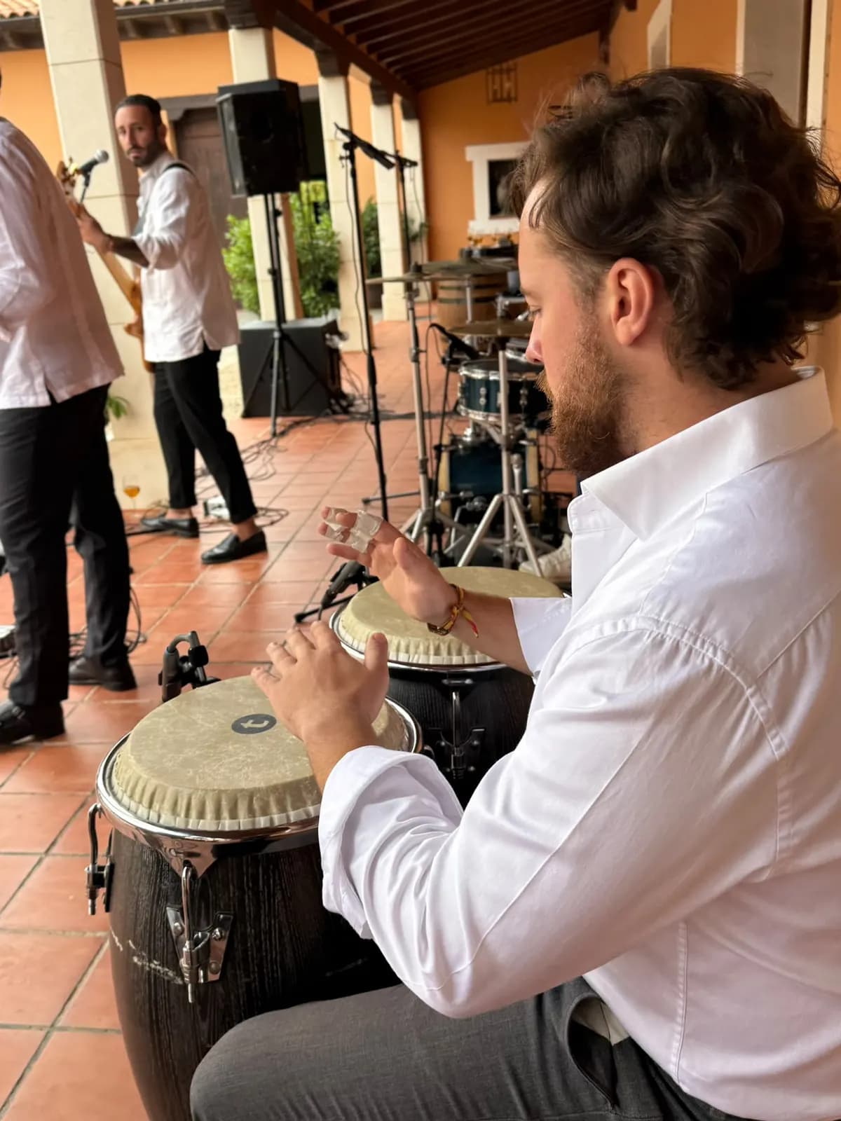 Percussionniste de Califa Jerezano avec les congas repiquées et, au fond, une enceinte de la façade sur pied