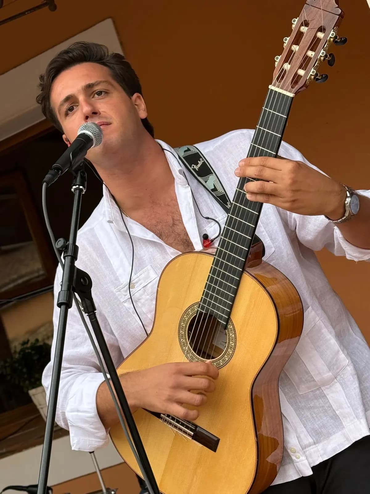 Chanteur et guitariste de Califa Jerezano chantant dans son micro au mariage de Los Aljibes