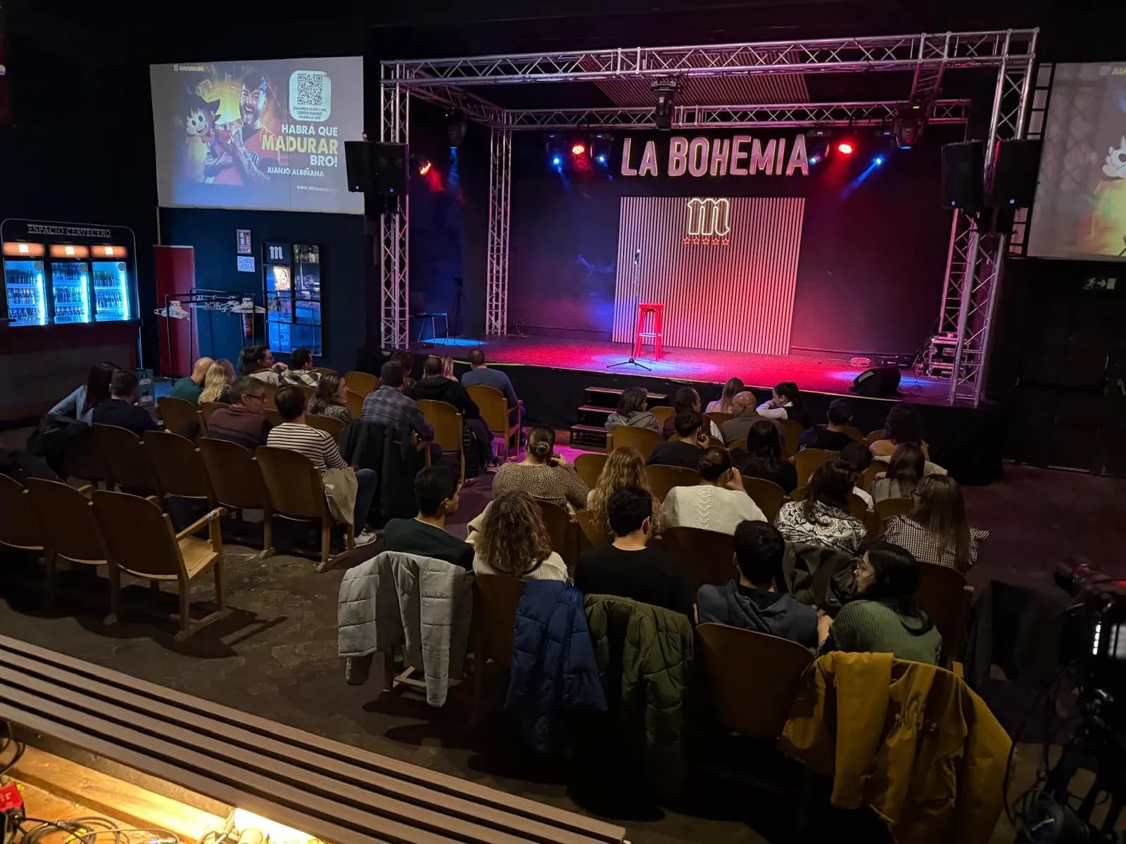 La Bohemia with the audience seated, the stage still empty and the screens advertising «¡Habrá que madurar, bro!»