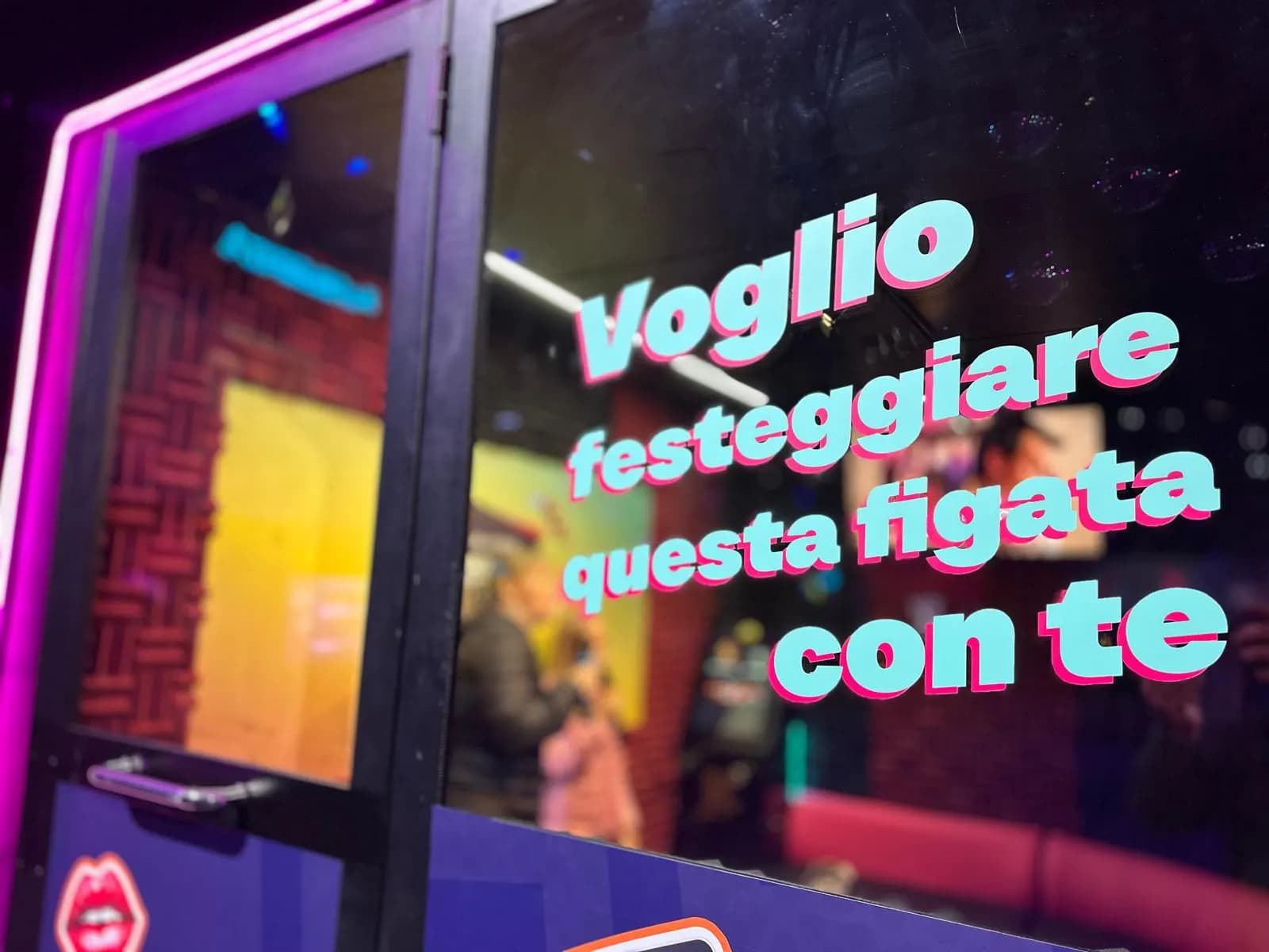 Karaoke booth glass with the slogan «Voglio festeggiare questa figata con te» and the interior with acoustic panels