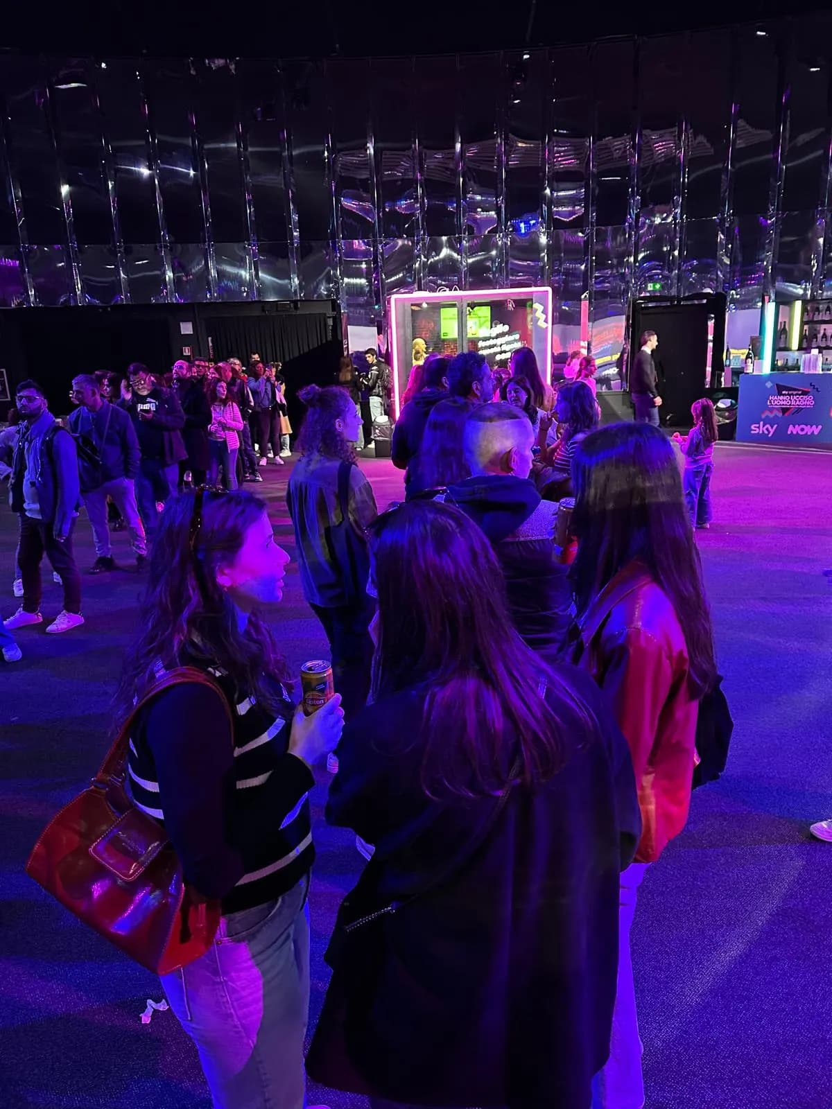Sky event space with guests and the lit karaoke booth in the background