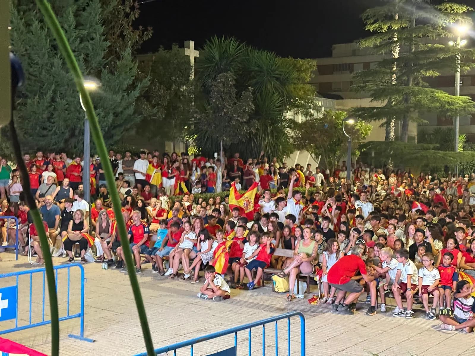 Públic assegut i amb banderes d'Espanya mirant el partit de nit a Caudete
